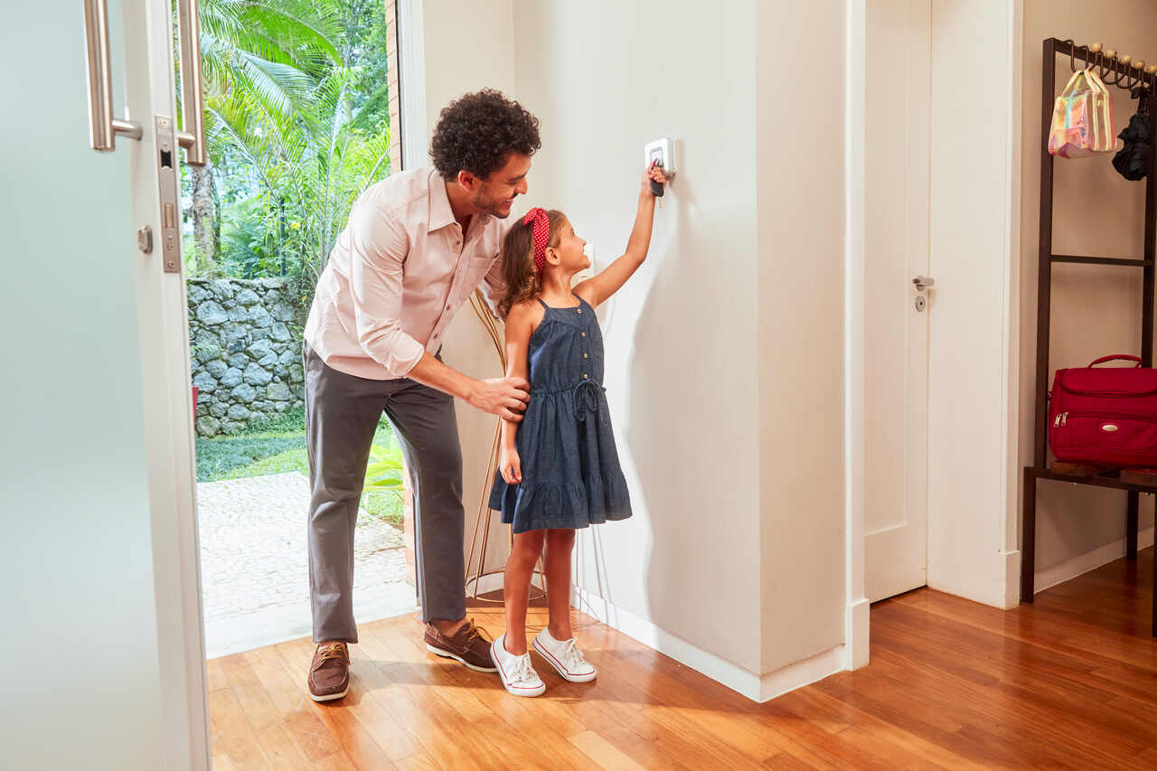 Pai e filha ativando o sistema de monitoramento Verisure.