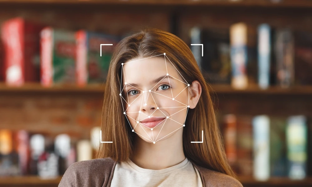 Imagem de uma jovem sorridente com reconhecimento facial, destacando a tecnologia de análise facial aplicada na imagem, em ambiente de biblioteca ou livraria.