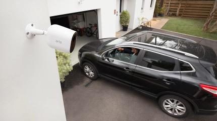 Carro entrando na garagem e câmera de segurança realizando o monitoramento.